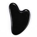 Polished black obsidian gua sha with mirror finish, heart-shaped facial massage tool