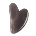 Agate gua sha stone with banded grey and rust colouring, heart-shaped facial massage tool