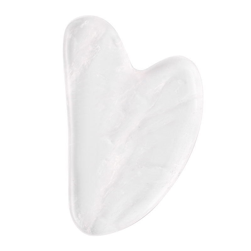 Clear white crystal gua sha stone with glass-smooth polish, heart-shaped facial massage tool